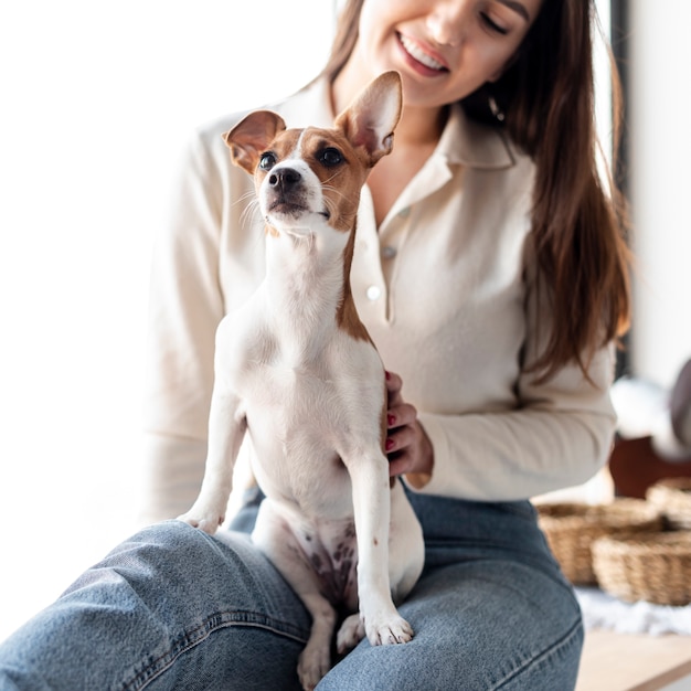 無料の写真 女性の膝に座っているかわいい犬