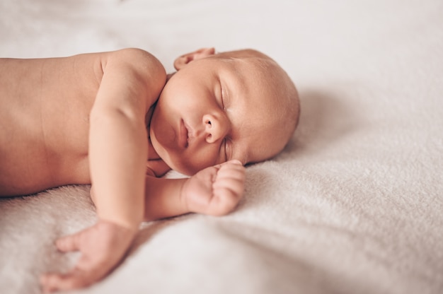 ベビーベッドで眠っているかわいい感情的な面白い新生児の男の子 プレミアム写真