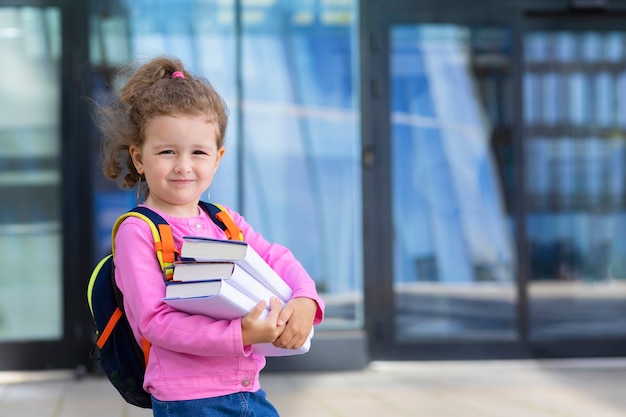 本とかわいい面白いスマート女子高生 学校の子供たちに戻る 幸せな子供 賢い女の子は秋の日に一年生に行きます プレミアム写真