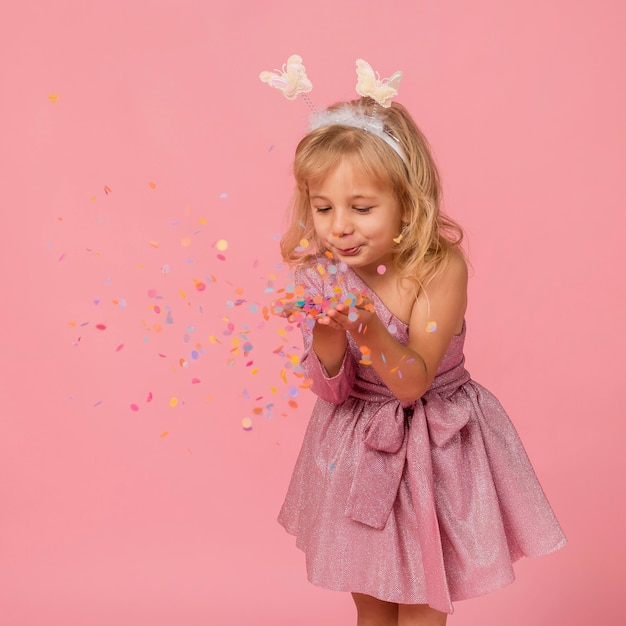 Cute girl blowing confetti Free Photo