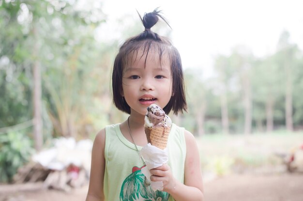 Premium Photo | Cute girl enjoy eating a melting chocolate ice-cream