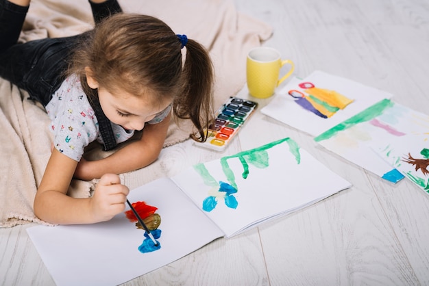 Free Photo | Cute girl painting with bright aquarelle on floor