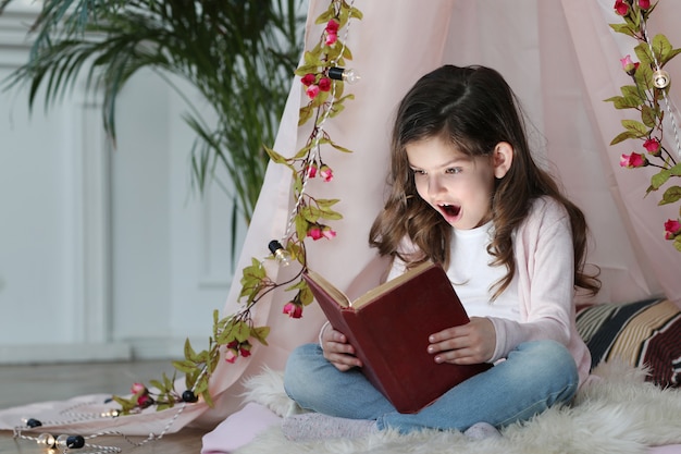 Cute girl reading a book around cute decoration Free Photo