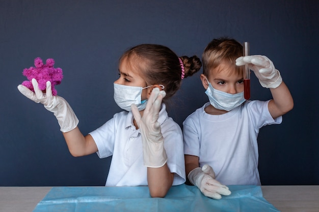 血液検査結果を保持している人工呼吸器のマスクと薬の手袋を身に着けているかわいい子供 プレミアム写真