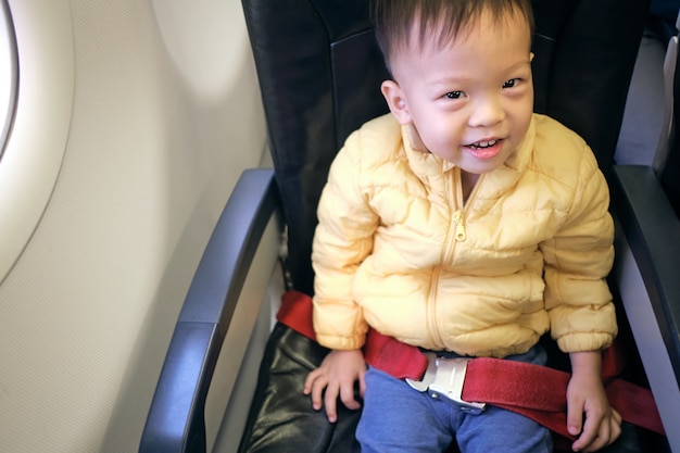 かわいい小さなアジア人2 3歳の幼児の男の子の子供が飛行機の飛行中に笑っている プレミアム写真