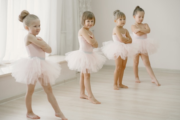 ピンクのバレエ衣装のかわいい小さなバレリーナ トウシューズを履いた子供たちが部屋で踊っています ダンスクラスの子供 無料の写真