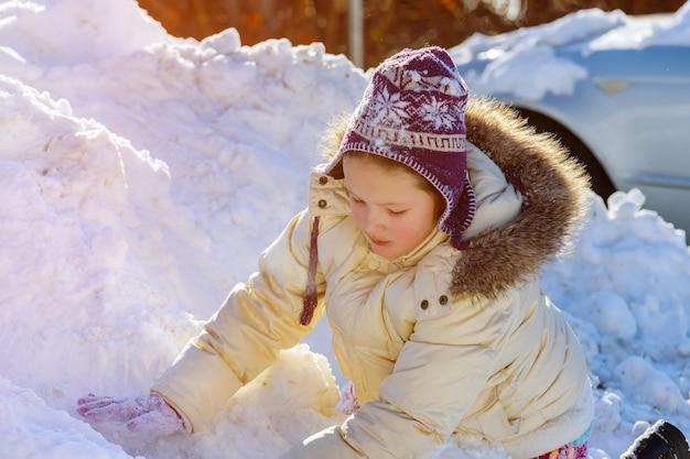 子供に冬の雪で遊ぶかわいい白人の女の子 プレミアム写真