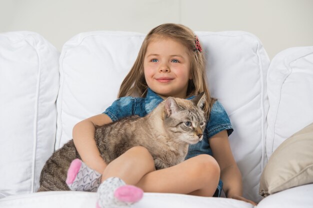 Premium Photo | Cute little girl hugging tabby cat with love, looking away.