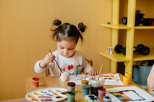 Premium Photo | A cute little girl is playing and painting in her room ...