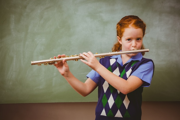 かわいい女の子 教室でフルートを弾く プレミアム写真