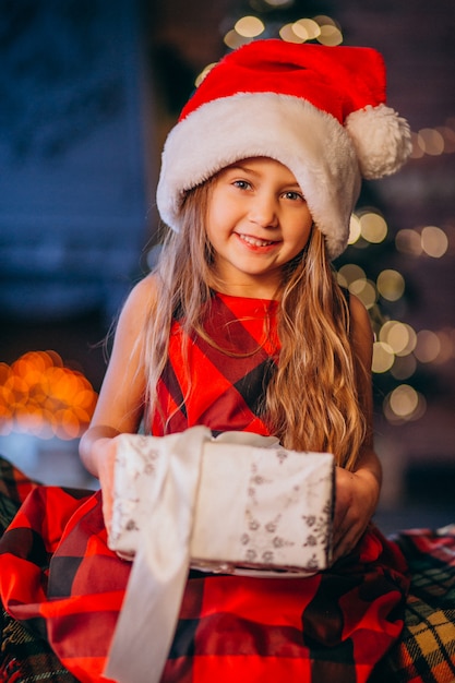 Free Photo Cute Little Girl In Santa Hat Unpacking Christmas Present