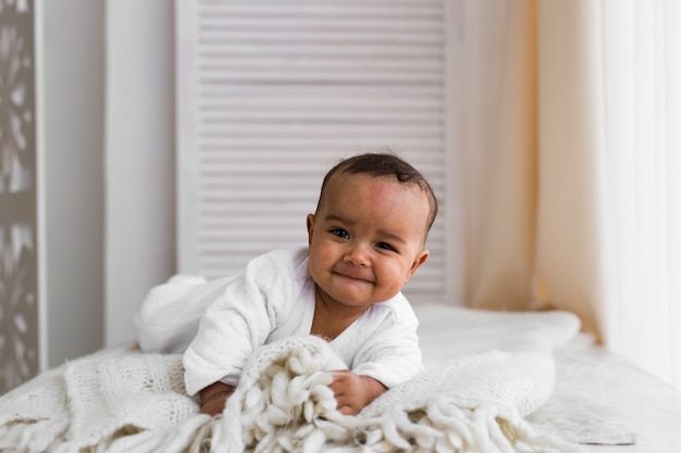 Premium Photo Cute Mixed Race African American Baby Boy Plays Inside On A Bed