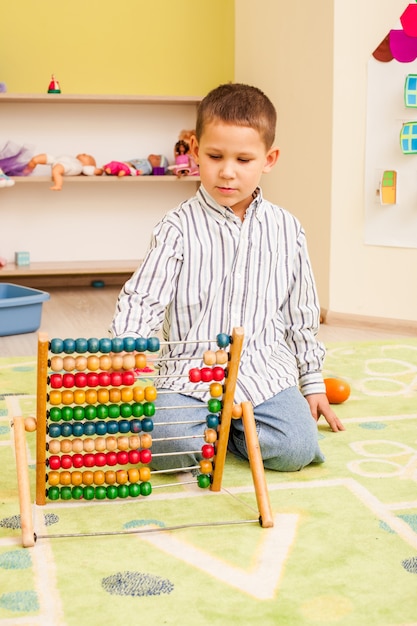 Premium Photo | Cute preschooler child boy playing with wooden color abacus