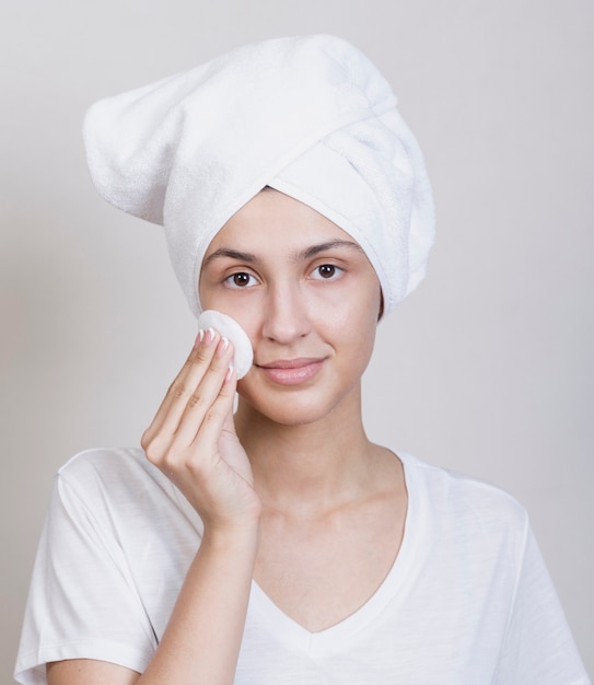 Cute woman cleaning her face Free Photo