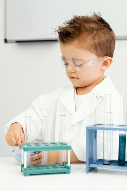 Free Photo | Cute young boy scientist doing experiments in the laboratory