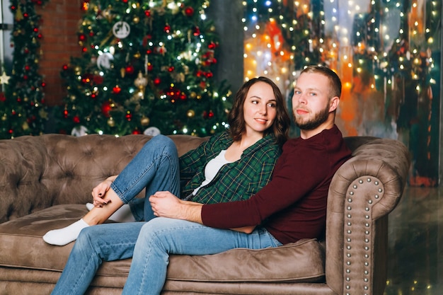 Premium Photo | Cute young family husband and wife at the christmas tree