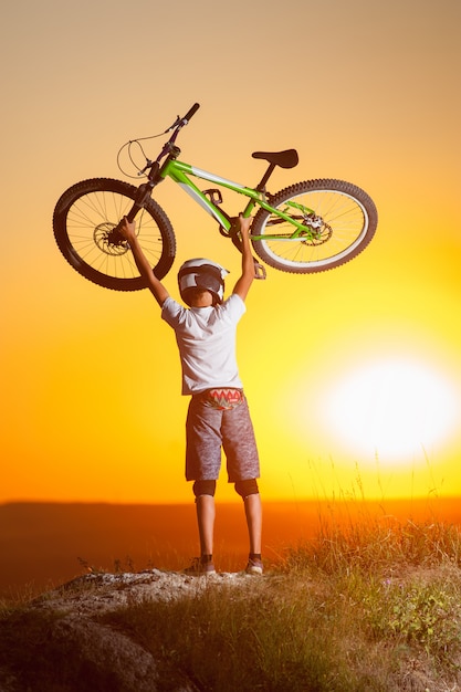 Cyclist with mountain bike on the hill in the evening Premium Photo