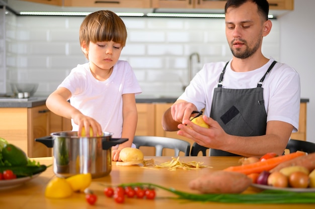 Free Photo | Dad and child peeling veggies