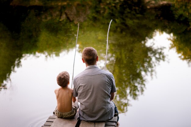 Premium Photo | Dad and son fishing on a lake