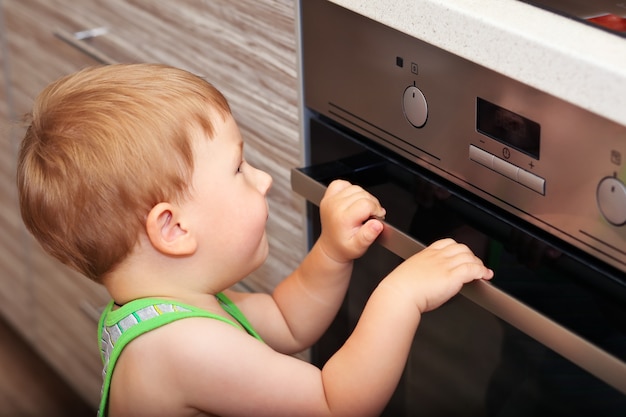 Premium Photo | Dangerous situation in the kitchen. child playing with ...