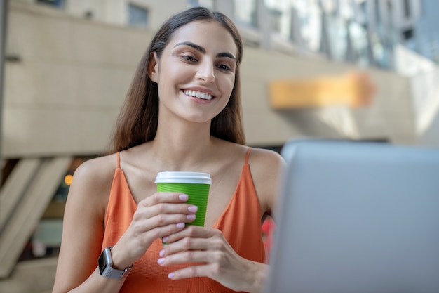 Premium Photo Dark Haired Pretty Woman Holding A Cup Of Coffee And