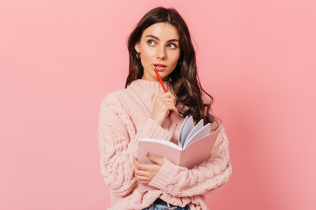 dark haired woman knitted sweater looks up thoughtfully lady thinks what write new book 197531 13537