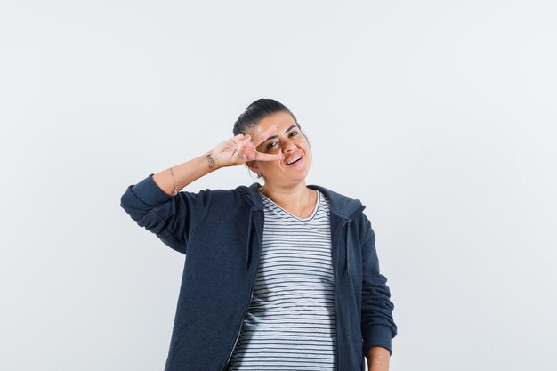 free-photo-dark-haired-woman-showing-v-sign-over-eye-in-shirt