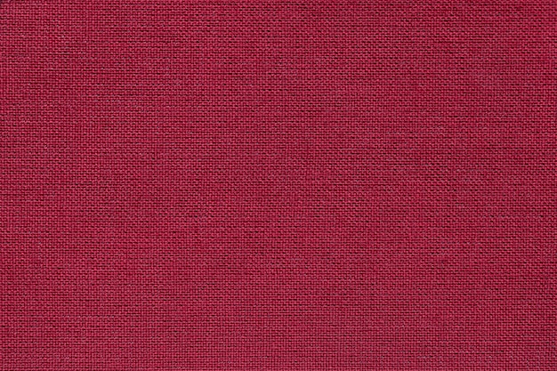 Dark red background from a textile material with wicker pattern, closeup. Premium Photo
