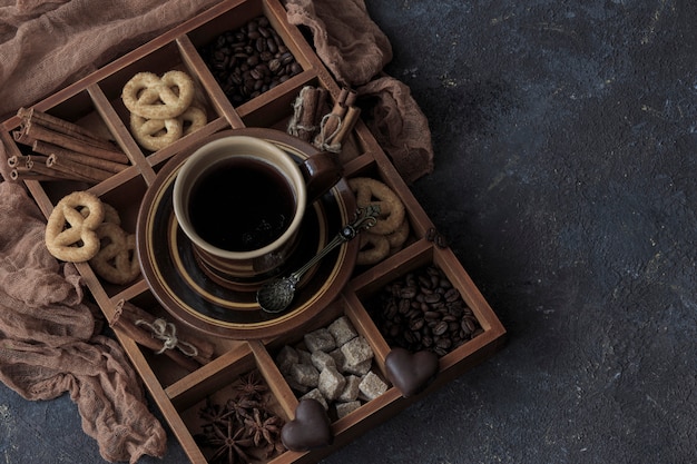 Download Premium Photo On A Dark Wooden Table A Cup Of Coffee Chocolate And Pretzels In A Box
