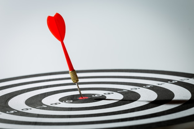Dart arrow hitting in the target center of dartboard. concept of the success Premium Photo