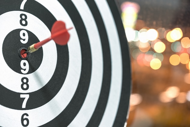 Dart target arrow hitting on bullseye with bokeh background Free Photo