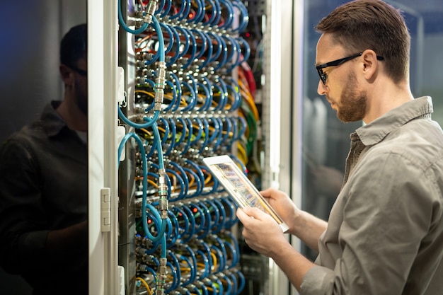 premium-photo-data-center-technician-checking-connections-on-tablet