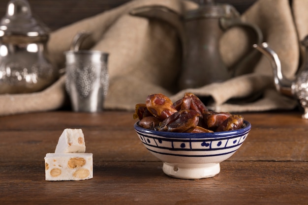 Dates fruit in bowl with turkish delight on table Free Photo
