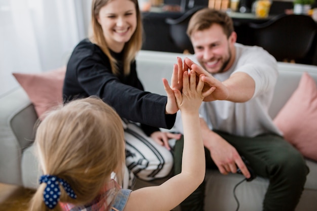 Daughter high-fiving with parents Free Photo