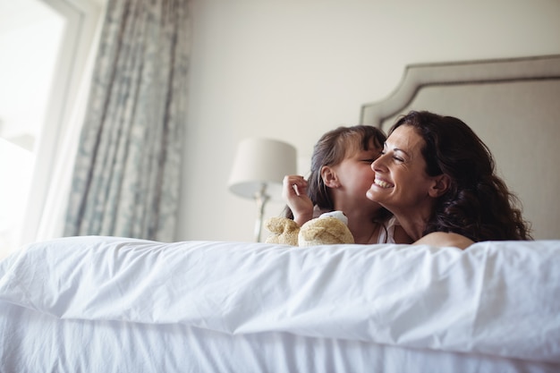 Premium Photo Daughter Kissing Her Mother On Cheek In Bedroom