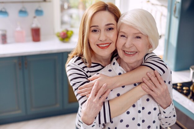 Premium Photo | Daughterly love. cheerful young woman hugging her ...