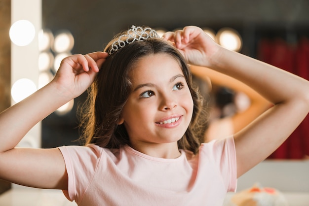  Daydreaming  girl  holding crown on her head looking away 