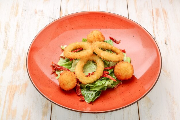 Premium Photo | Deep batter fried squid rings calamari with green salad