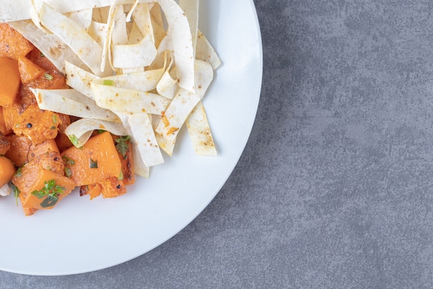 Delectable sliced lavash and baked carrot in plate , on the marble surface. Free Photo