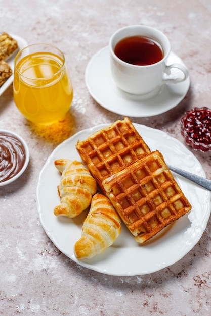 https://image.freepik.com/free-photo/delicious-breakfast-with-coffee-orange-juice-waffles-croissants-jam-nut-paste-on-light-top-view_114579-4957.jpg