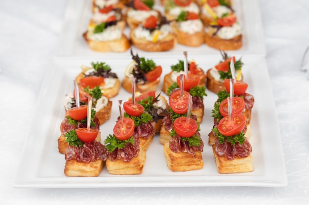 Premium Photo | Delicious canape with sausage and tomato.canapes on ...