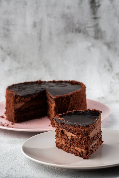 大理石の背景にテーブルの上の皿においしいチョコレートケーキ ペストリーカフェやカフェメニューの壁紙 垂直 プレミアム写真