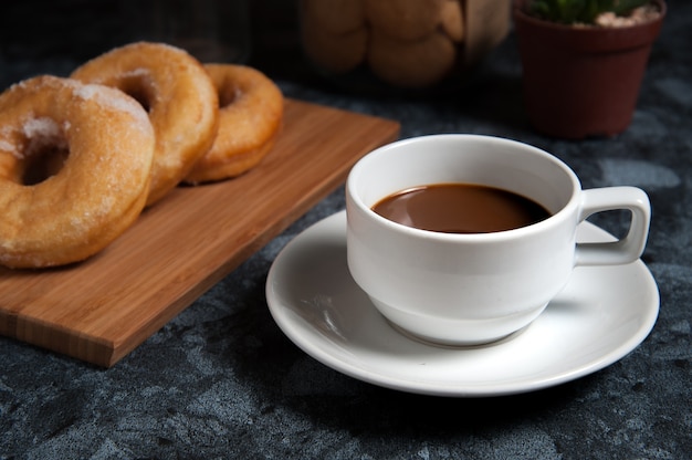 Premium Photo | Delicious donuts with icing and cup of coffee in plate ...