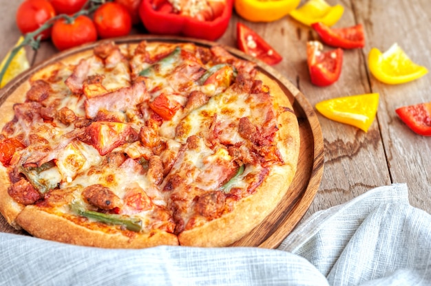 Delicious italian pizza sliced with bacon, cheese, tomato ...