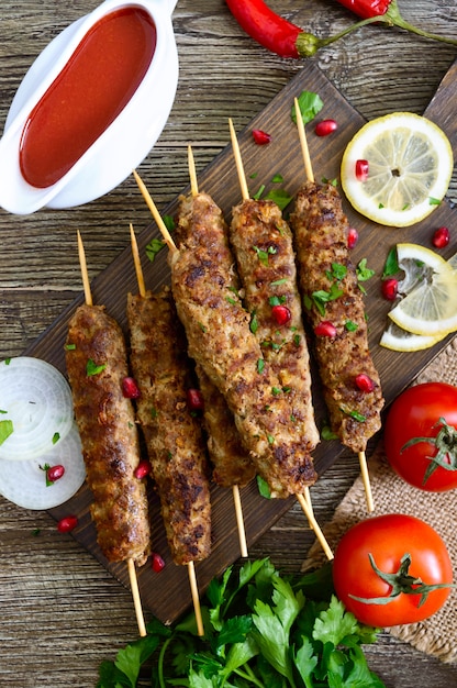 Premium Photo | Delicious lula kebab on a wooden table. chopped meat on ...