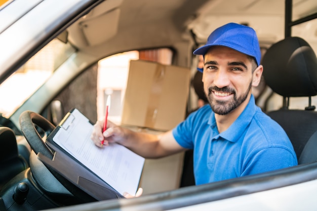 Premium Photo | Delivery man checking delivery list in van.