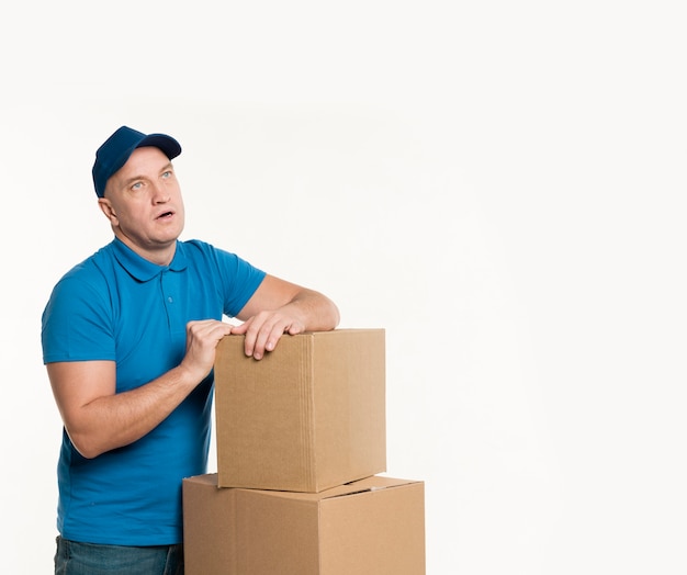 Free Photo | Delivery man with cardboard boxes posing while exhausted