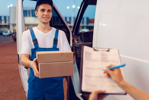 Premium Photo | Deliveryman In Uniform Gives Parcel To Female Recipient