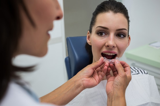 Dentist assisting a patient to wear invisible braces Free Photo