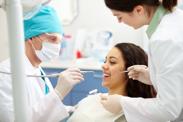 Dentist examining a patient's teeth | Free Photo